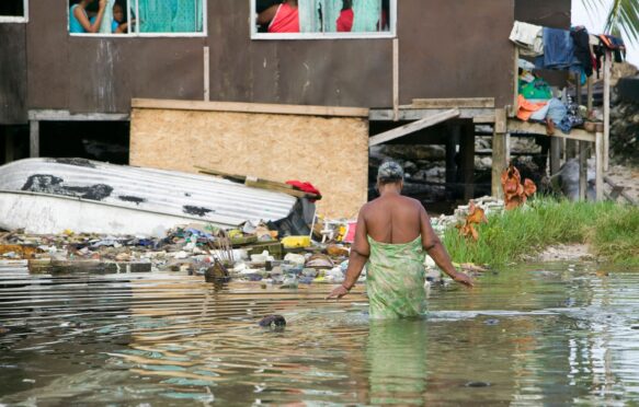 A woman wades through flood water in Tuvalu.
