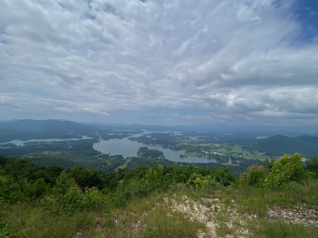 Image taken from Bell Mountain showing a view of Lake Chatuge in the distance, with trees and grass in the foreground.